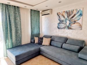 uma sala de estar com um sofá e uma pintura na parede em Oazis resort lux vip apartament em Lozenets