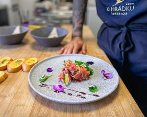 a plate of food on a table with a person at U HRÁDKU Superior in Znojmo