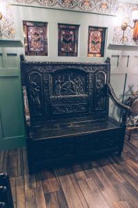 czarna ławka siedząca na drewnianej podłodze w obiekcie Sheddington Manor - 2 Bedroom Guest House & Cinema w mieście Belfast