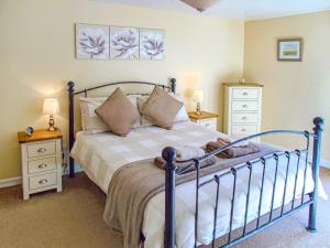 a bedroom with a bed and two night stands at Higher Hopworthy Cottage-uk11436 in Pyworthy