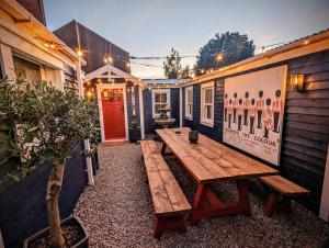 a wooden picnic table sitting outside of a building at Sheddington Manor - 2 Bedroom Guest House & Cinema in Belfast