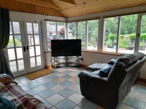 ein Wohnzimmer mit Couch und Flachbildfernseher in der Unterkunft Moira Cottages at Berwickhall Sleeps 8 in Moira