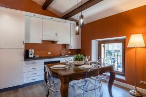 uma cozinha com uma mesa de madeira e armários brancos em (Sferisterio) Casa Carmen con idromassaggio em Macerata