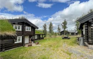 a backyard of a log house with a yard at 4 Bedroom Amazing Home In Nord-torpa in Nord Torpa