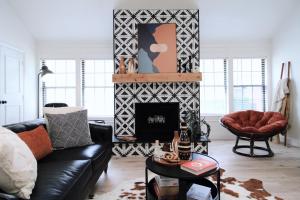 a living room with a black couch and a fireplace at The Sleepy Owl in Plano