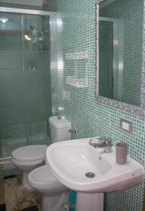 a bathroom with a sink and a toilet and a mirror at Mirage Place B&B in Catania