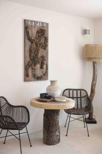 サン・アントニオ・ベイにあるCasa dos Islas Loftのテーブルと椅子2脚と絵画が備わる部屋