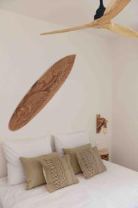 a surfboard is hanging above a bed with pillows at Casa dos Islas Loft in San Antonio Bay