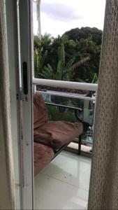 una puerta corredera de cristal con una silla en el balcón en brisa praiana, en Río de Janeiro