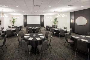 a conference room with tables and chairs and a screen at Residence Inn by Marriott Calgary South in Calgary
