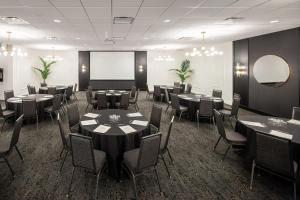 einen Konferenzraum mit Tischen, Stühlen und einem Bildschirm in der Unterkunft Residence Inn by Marriott Calgary South in Calgary