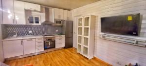 uma cozinha com armários brancos e uma televisão de ecrã plano em FINCA BEROLO 4 em Guía de Isora