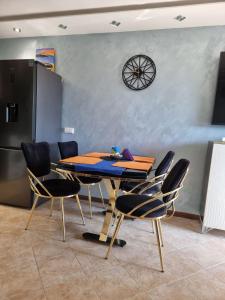 a dining room with a table and chairs and a clock at Oazis resort lux vip apartament in Lozenets