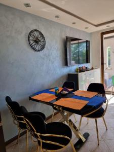 uma mesa de jantar com cadeiras e um relógio na parede em Oazis resort lux vip apartament em Lozenets