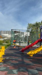 a playground with yellow and red equipment in a park at Жилой комплекс «Лавиния-1» in Erdemli