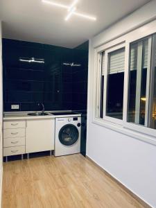 a laundry room with a washing machine and a sink at Apartamento Delfin - Punta Umbria in Punta Umbría