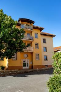 un edificio giallo con un albero di fronte di Golden Leaf Sladkovskeho a Olomouc