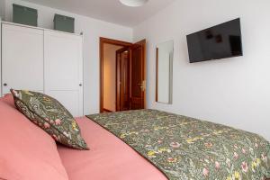 1 dormitorio con 1 cama y TV de pantalla plana en Delux3Rooms by Asturias Holidays, en Gijón