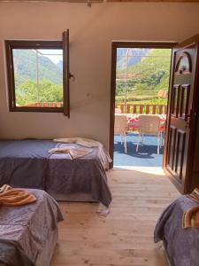 a room with two beds and a large window at Guesthouse Zvina in Pukë
