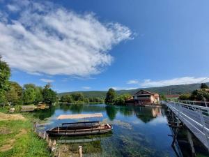 una barca su un fiume vicino a una casa di Villa Hacienda - Holiday Home a Bihać