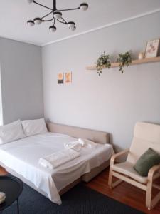 a small bedroom with a bed and a chair at Letos Apartment Sky in Kavála