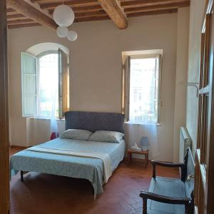 a bedroom with a bed and two windows at Casa Garibaldi in Lucca