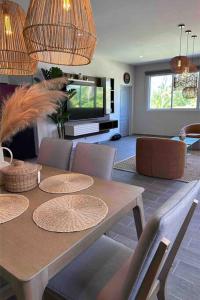 a living room with a table with chairs and a television at Another Day In Paradise in San Luis La Herradura