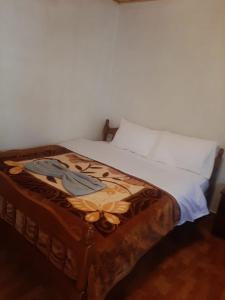 ein Bett mit einem Bild eines Schmetterlings drauf in der Unterkunft Guesthouse Zvina in Pukë