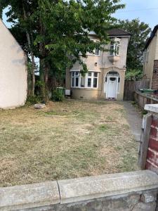 a house with a white door and a yard at Hallykins in Erith