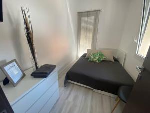 LuLu Naxos Apartment في جيارديني ناكسوس: غرفة نوم مع سرير ومكتب مع الكمبيوتر المحمول