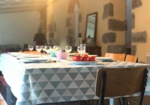 uma mesa com pratos de tomate e taças de vinho em Maison d'Agathe em Bouessay