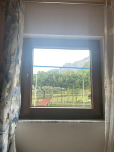 a window in a bathroom with a view of a mountain at Guesthouse Zvina in Pukë