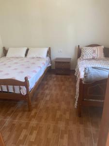a bedroom with two beds and a wooden floor at Guesthouse Zvina in Pukë