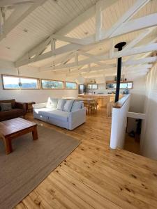 a living room with a white couch and a table at Buchuvillas Surf House in Buchupureo
