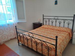 sypialnia z łóżkiem z pomarańczowym kocem w obiekcie DreamHouse Ischia-Lacco Ameno in pieno centro a soli 70 metri dal mare! w mieście Ischia