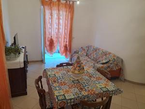 uma sala de estar com uma mesa e um sofá em DreamHouse Ischia-Lacco Ameno in pieno centro a soli 70 metri dal mare! em Ischia