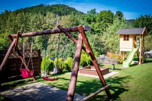 un columpio en un patio con parque infantil en Jakubówka, en Szczawnica