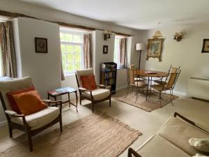 a living room with a table and chairs at Watermill Cottages - 18th Century converted Mill 10 mins from beach in Dartmouth