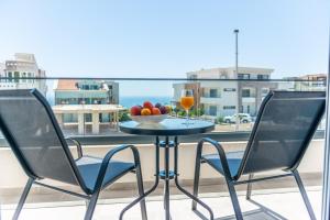 a table with a bowl of fruit and a glass of wine at Twins Apartment in Ulcinj