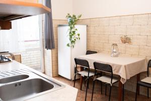 una cucina con tavolo, sedie e lavandino di Апартаменти на Сихові 3й a Lviv Altre 11 foto