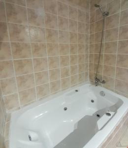 Hotel Bianca Boutique في فينيا ديل مار: حوض استحمام أبيض في حمام من البلاط