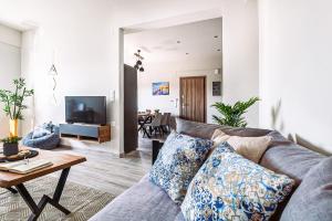 uma sala de estar com um sofá e uma televisão em Holiday House Heraklion Deluxe em Iráclio