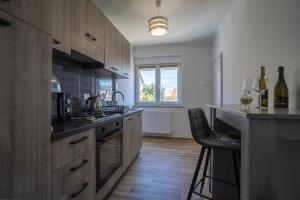 a kitchen with wooden cabinets and a counter top at Apartman Josip in Gospić