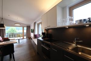 kuchnia ze zlewem i kuchenką górny piekarnik w obiekcie SeeHotel & SeeApartments Kärntnerhof- direkt am See! w mieście Weissensee