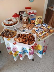 una mesa llena de diferentes tipos de pan y repostería en B&B La Perla, en Castro di Lecce