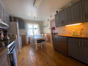 Vanvik的住宿－Feriested i Vanvik，厨房铺有木地板,配有桌子。