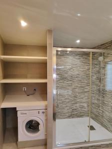 uma casa de banho com uma máquina de lavar roupa e um chuveiro em Family apartment Besos em Barcelona