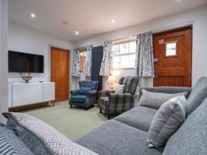 a living room with a couch and chairs and a tv at Walnut Cottage - Uk43995 in Fairfield