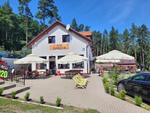 um edifício com mesas, cadeiras e guarda-sóis em Domek Seleny w Dolinie Symsarny em Lidzbark Warmiński