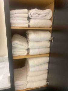 een kast gevuld met witte handdoeken op een plank bij Luxurious Apartment Home in Creve Coeur
